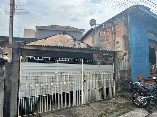 Casa térrea a esquerda e salão do lado