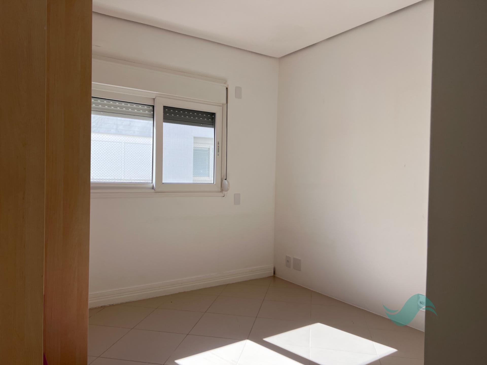 Dormitório do apartamento em Jurerê Internacional, com piso porcelanato e boa iluminação natural
