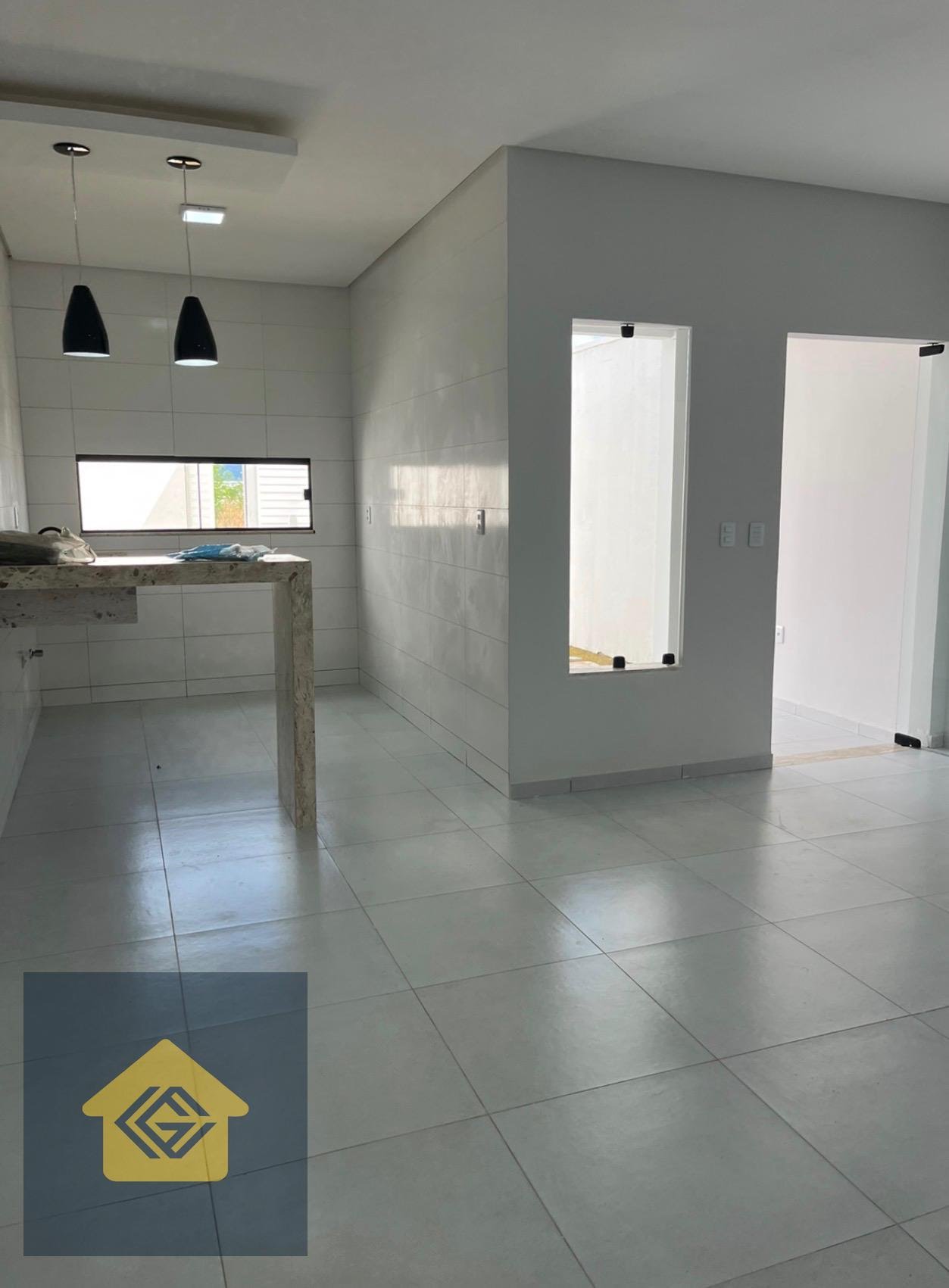 Cozinha com bancada e sala de estar e jantar