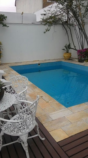 piscina com deck de madeira e pedra