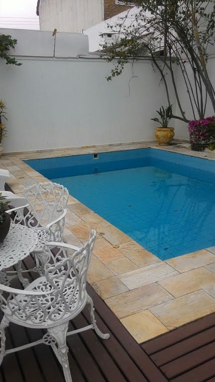 piscina com deck de madeira e pedra
