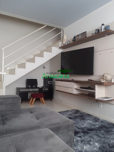 Sala com painel de TV e sofá