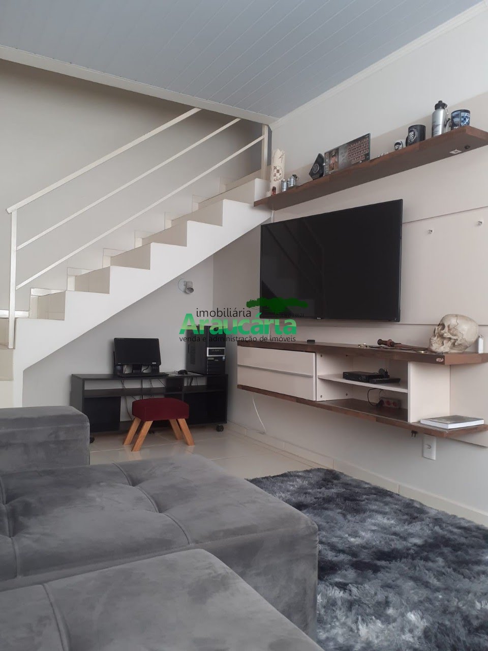 Sala com painel de TV e sofá
