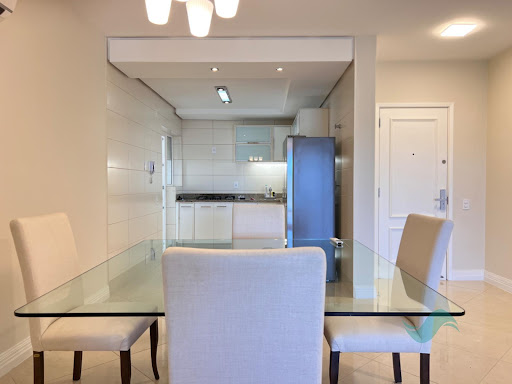 Sala de jantar com cozinha americana do apartamento em Jurerê Internacional