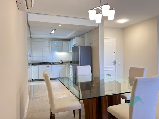 Cozinha integrada à sala de jantar do apartamento em Jurerê Internacional