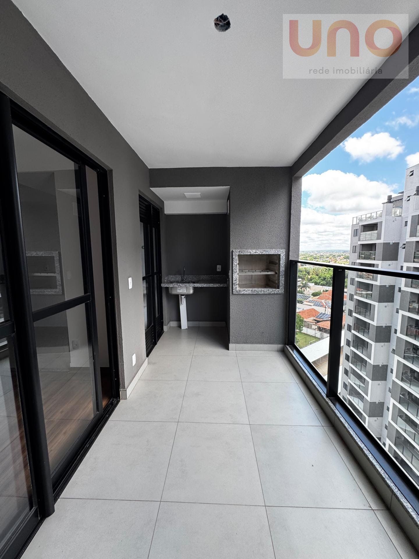 Varanda separada dos ambientes da sala e cozinha